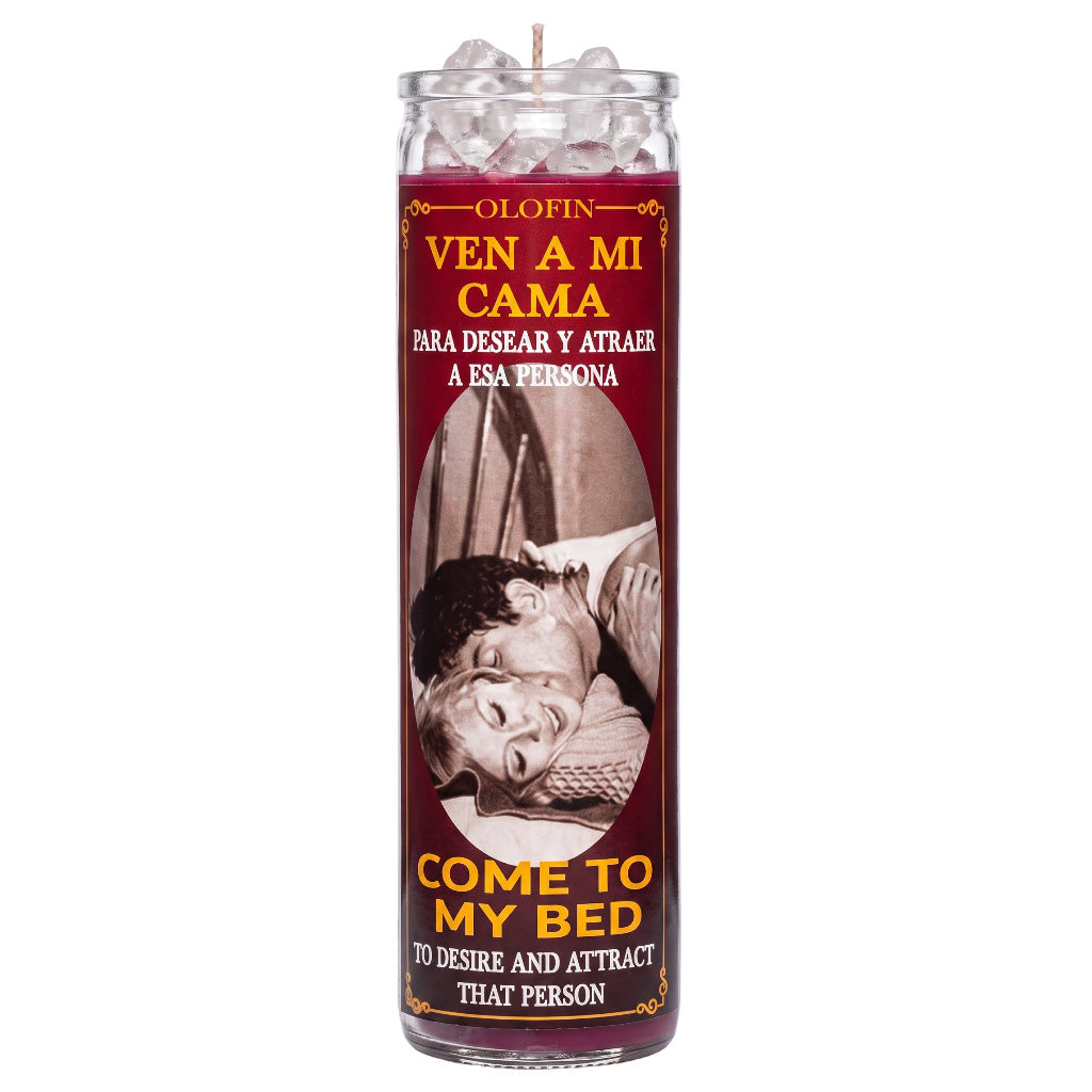 A tall glass jar candle with a maroon label reading 'Olofin Ven a mi cama' and 'Come to my bed' in yellow text, featuring a vintage-style couple photo on the front. The candle is shown upright on a plain white background.