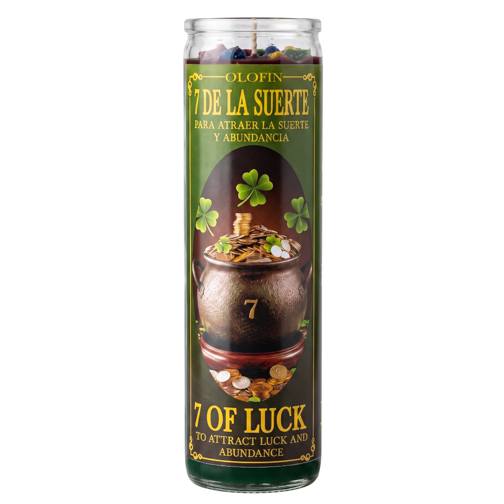 A tall glass jar candle labeled '7 DE LA SUERTE / 7 OF LUCK' with a green label showing a brown pot, shamrocks, coins, and the number 7. The candle is photographed on a plain white background.