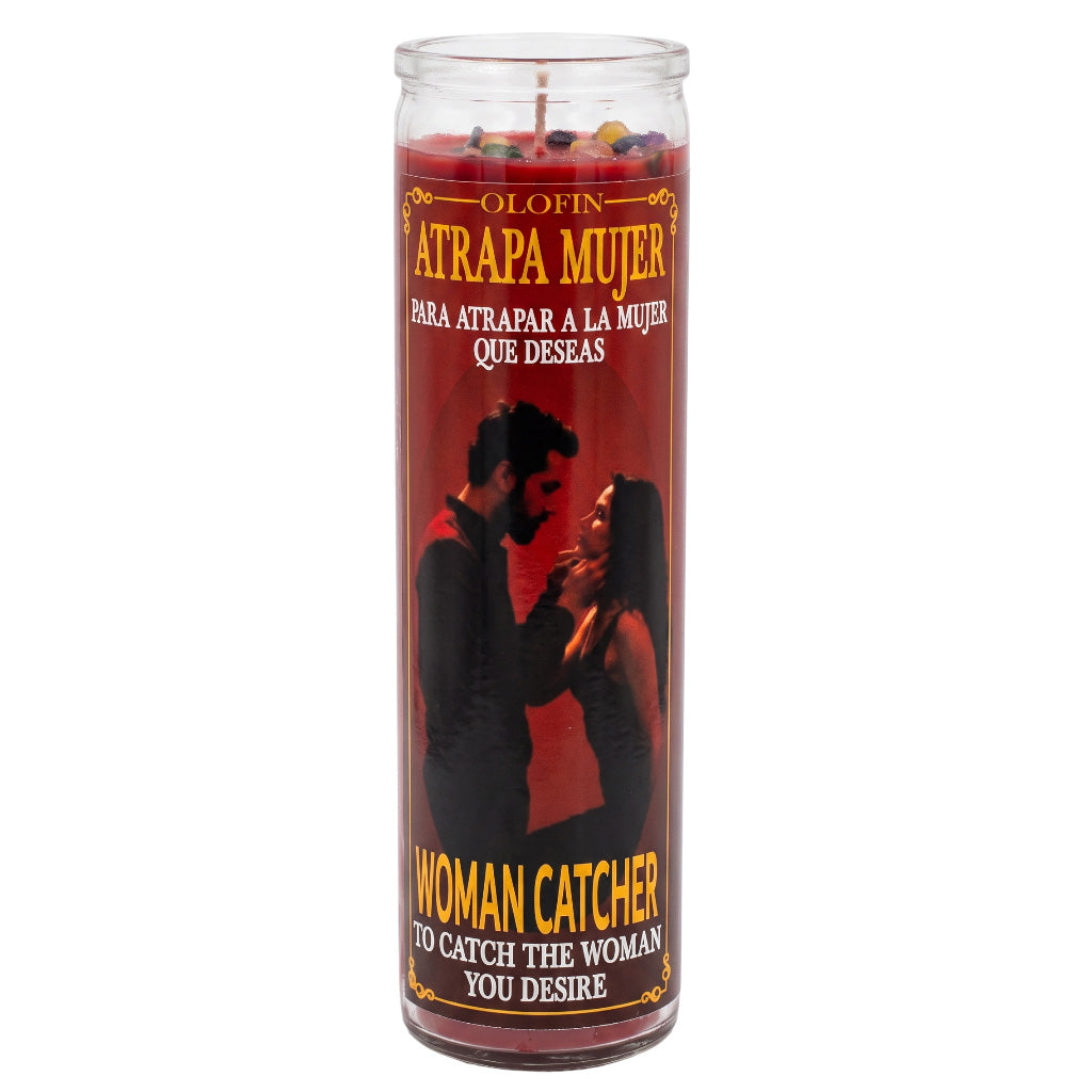 A tall glass jar candle with red wax and a printed label reading 'Atrapa Mujer' and 'Woman Catcher,' featuring a black silhouette of a couple on the front, photographed on a plain white background.