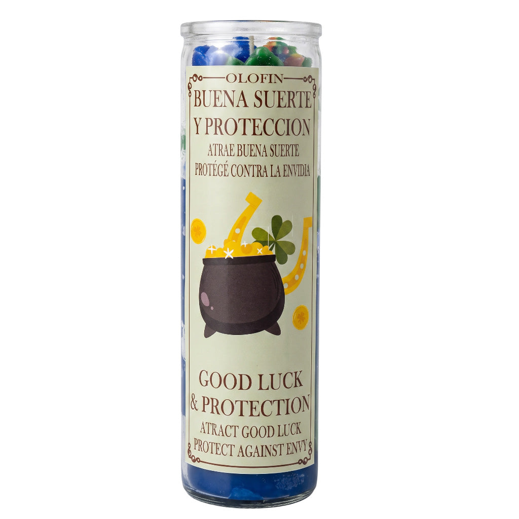 A tall glass jar candle with a clear lid and a cream-colored label featuring a cauldron, horseshoe, and clover illustration. The label reads 'Olofin Buena Suerte Y Proteccion' and 'Good Luck & Protection'.