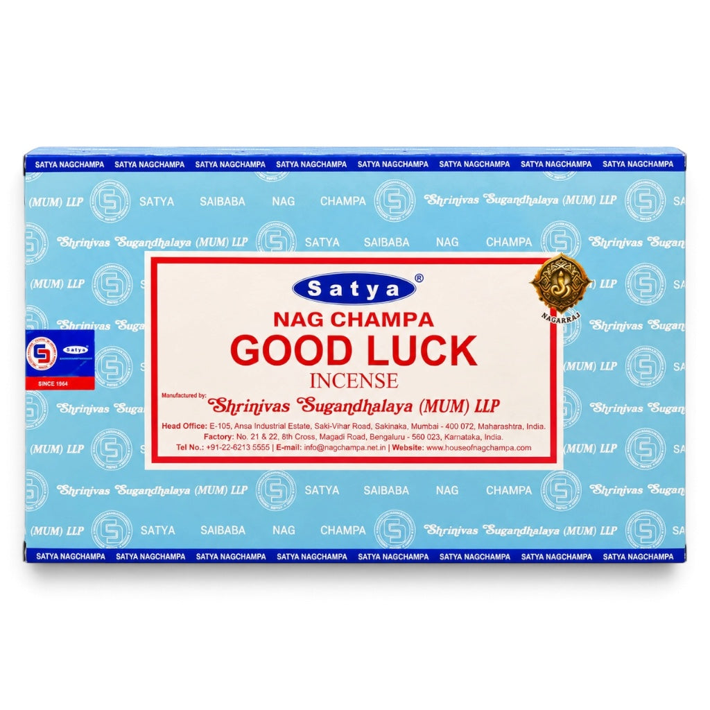 A rectangular box of Satya Nag Champa Good Luck incense, featuring a light blue patterned background with a large white central label containing red and blue text.