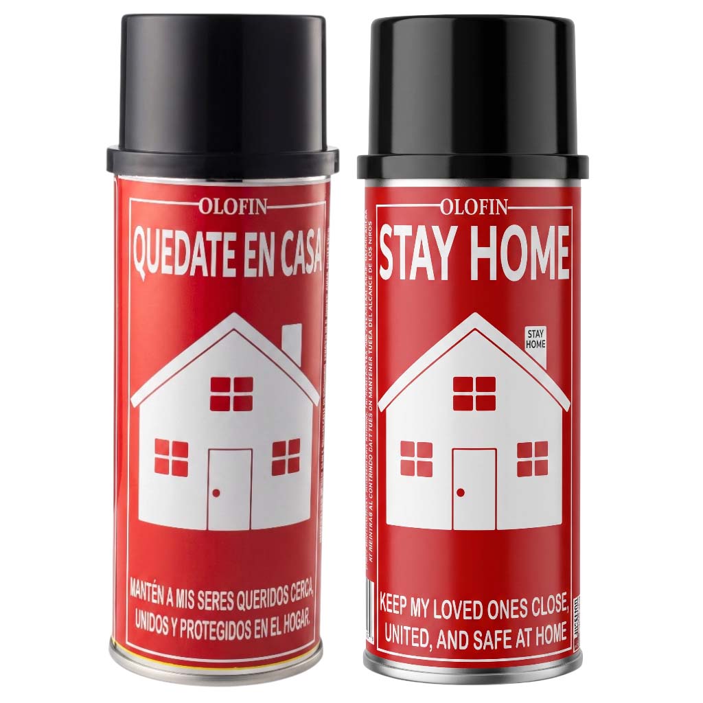 Two Olofin Stay Home aerosol cans with red labels and black caps, featuring a white house graphic and Spanish and English text, on a white background.